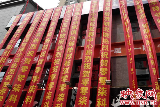 路邊一棟樓上懸掛著二三十條紅色條幅，全部是祝賀一家公司開(kāi)業(yè)的。