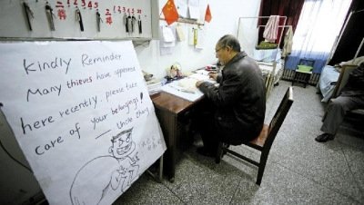 張大爺在門衛(wèi)室里工作，旁邊是紅爆網(wǎng)絡(luò)的溫馨提示牌記者