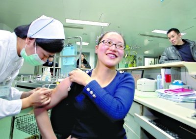 昨日，向雪敏在同濟醫(yī)院血液科病房打動員劑，丈夫陳武右在身后注視著妻子 記者傅克強