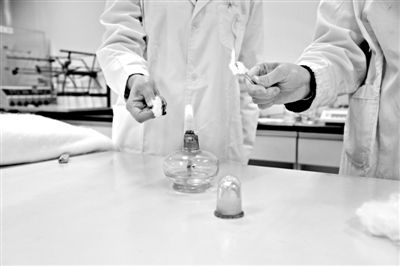 實驗人員操作的燃燒檢測法中，真蠶絲離開火焰就熄滅(左)。