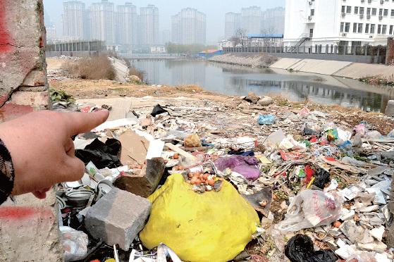 金水河長江路橋下河水發(fā)臭，水邊堆放眾多垃圾