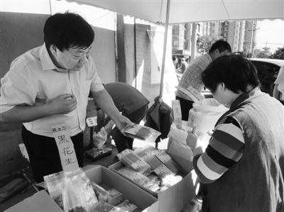昨日，河南企業(yè)家劉春喜在京“練攤”，為顧客挑選綠豆。新京報(bào)記者 張玉學(xué) 攝
