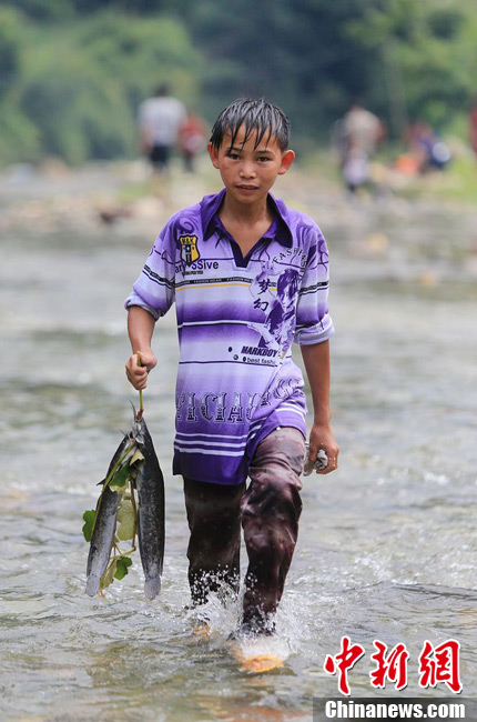 圖為7月9日，一名男孩在鬧魚節(jié)活動(dòng)中抓到了兩條魚。譚凱興 攝