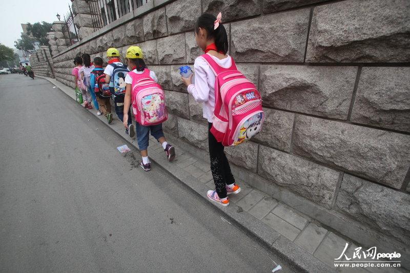 2013年09月11日，濟(jì)南運(yùn)署街上，小學(xué)生走史上“最窄人行道”上學(xué)。
