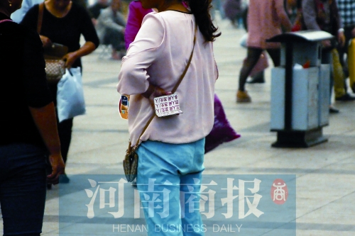 火車站廣場(chǎng)，一女子拿著寫有不同房型價(jià)位的卡片在拉客，不少市民抱怨，受過(guò)此類“騷擾”