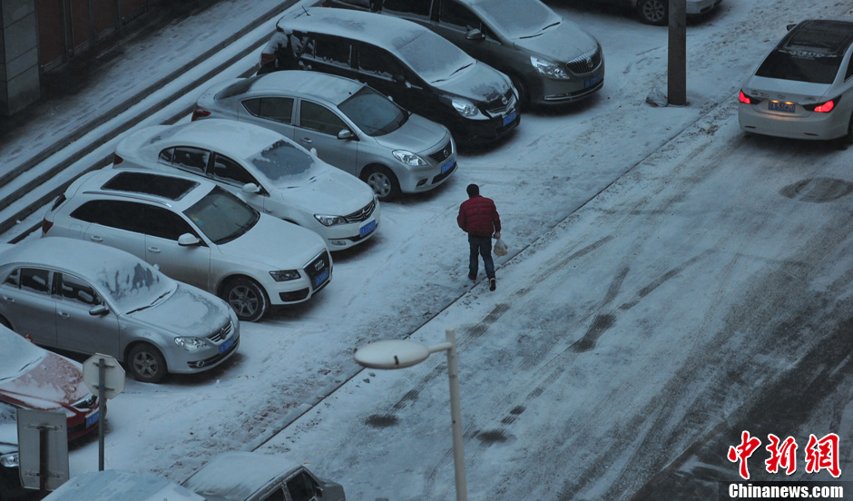 11月18日，行人在沈陽街頭的積雪中穿行。