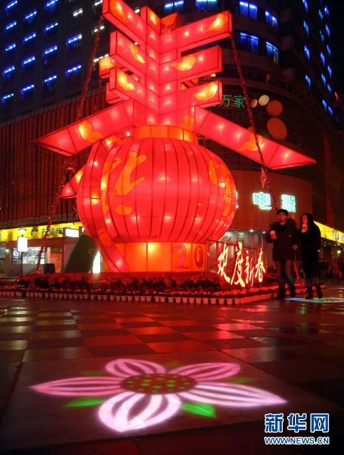 　1月30日晚，市民從蘇州市石路銀河廣場上大型“春”字彩燈景觀旁經(jīng)過。