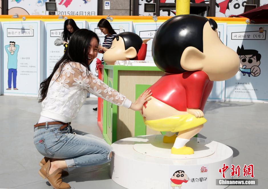 4月22日，游客與蠟筆小新合影。“蠟筆小新25周年紀念特展”日前在北京開展，吸引了不少市民游客。