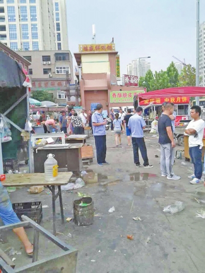 昨天，執(zhí)法人員在京廣路長(zhǎng)江路口整治“僵尸圍擋”及圍擋內(nèi)的攤販。
