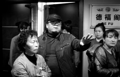 昨日，在河北香河天下第一城，相關(guān)負(fù)責(zé)人（左二）走出會(huì)議室與參加演出的老人們溝通。