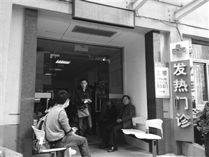 到浙大一院發(fā)熱門診就診的病人增多，不少人在門口等候