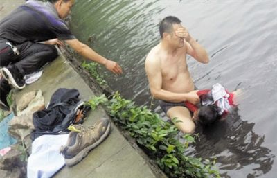 網(wǎng)友貼出民警張光聰一出河水就睜不開眼，用手抹去臉上臟水的照片。