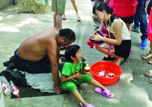 記者找到小女孩時(shí)，男子正帶著她在中央路上乞討 記者 施向輝/攝
