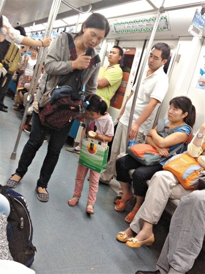 6月27日，舒馨帶一女孩在地鐵十號(hào)線行乞。她因被疑帶多個(gè)不同小孩乞討被警方搜尋。新京報(bào)記者 申志民 攝