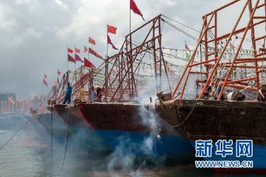 2013年8月1日 南海開漁日 臨高迎新港 8月1日，海南省臨高縣漁民在船上鳴放鞭炮慶祝武蓮港開港。