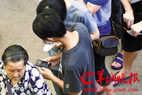 排隊(duì)的“黃?！备魇謭?zhí)一疊白紙，上面寫好了要掛號(hào)的人的信息，包括姓名、電話、要掛的科室等。穿黑白花紋衣服的老婆婆正在排隊(duì)掛號(hào)