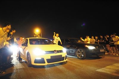 8月24日晚，東壩中街飆車(chē)現(xiàn)場(chǎng)，兩輛車(chē)并排等待出發(fā)指令，旁邊許多愛(ài)好者前來(lái)觀看比賽。新京報(bào)記者