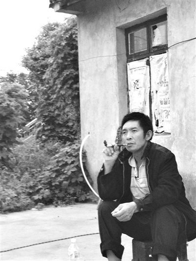 9月12日，陳文才在自己的出租屋旁抽煙。新京報(bào)記者 朱柳笛 攝