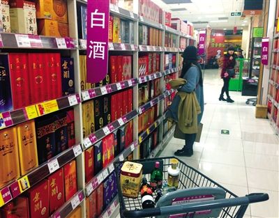 顧客在商場的高檔白酒貨架前駐足挑選。春節(jié)臨近，受“禁令”影響，以高檔白酒為代表的節(jié)日禮品市場面臨考驗(yàn)。記者 王遠(yuǎn)征 攝