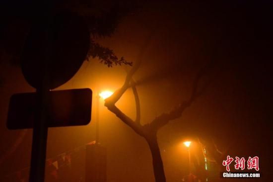 1月31日凌晨，市民行走在煙霧繚繞的南京街頭。當(dāng)天是農(nóng)歷馬年正月初一，南京有限開禁燃放煙花爆竹正逢下霧天，空氣的不流通致使煙花爆竹燃燒后產(chǎn)生的顆粒物不能及時(shí)散開，造成整座城市煙霧繚繞。據(jù)當(dāng)?shù)丨h(huán)保部門發(fā)布的信息顯示，空氣質(zhì)量屬重度污染。中新社發(fā) 泱波 攝