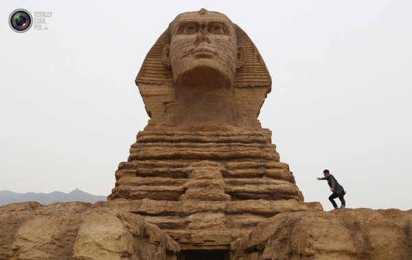 石家莊郊外，一名男子與山寨版獅身人面像合影留念。