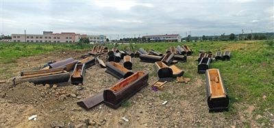 40多副棺木被砸壞后，扔在荒地上。