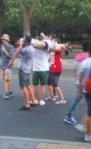 　四名外籍男子一同扛起醉漢拍照。