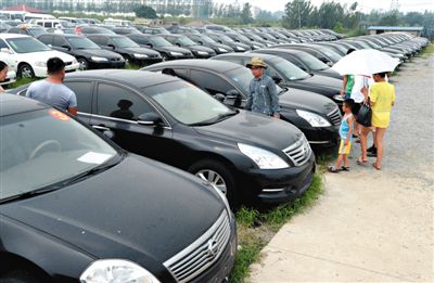昨日，市民在山東棗莊一家拍賣公司場地上查看待拍賣公車。當日，棗莊市103輛公車公開拍賣。新華社記者