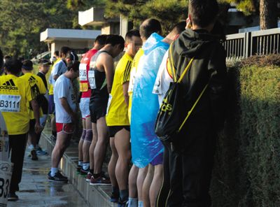 2013年10月20日，北京馬拉松比賽，由于廁位有限，一些選手在綠化帶“就地解決”。圖/IC