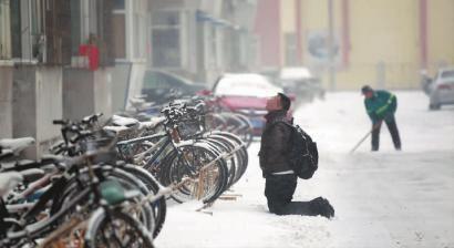 小伙子跪在樓前，一直抬頭看著樓上。 孫立國(guó)/攝