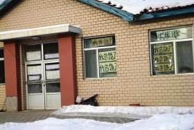 伊春市帶嶺區(qū)一排破舊的平房，房間窗戶上貼滿了“我告饒了”的字樣。