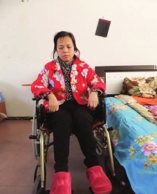 陳慶霞坐在輪椅上。她現(xiàn)在下身癱瘓，疾病纏身，生活不能自理。