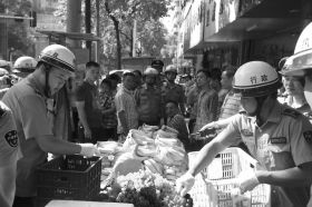 7月11日，瀏陽(yáng)市北正中路，執(zhí)法人員暫扣張海的水果。這是瀏陽(yáng)市城管局拍攝的執(zhí)法現(xiàn)場(chǎng)圖。