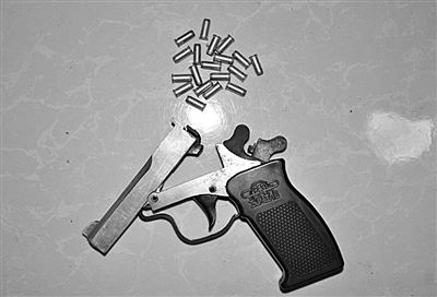 警方從搶劫嫌疑人處起獲的贓款和發(fā)令槍、子彈。警方供圖