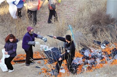 1月4日，連霍高速蘭州市榆中縣和平鎮(zhèn)段，一名警察舉著槍驅(qū)散哄搶橘子的村民。圖/CFP