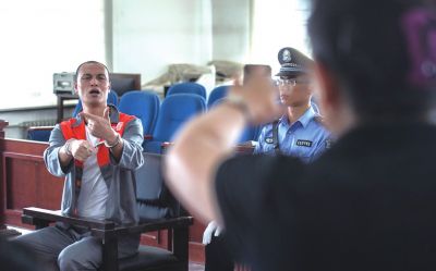 張志國在法庭上用手語回答提問。記者 蒲東峰攝