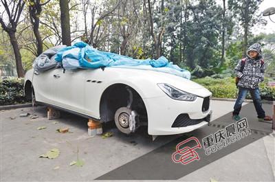 昨日，停放在重慶大學(xué)B區(qū)的一輛瑪莎拉蒂豪車被架在幾塊磚頭上，車輪不翼而飛。 重慶晨報(bào)記者 胡杰 攝
