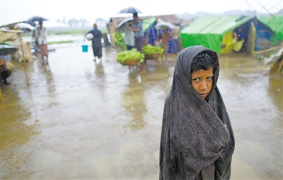 5月14日，緬甸若開邦實(shí)兌難民營，羅興亞族難民在雨中行走。熱帶風(fēng)暴“馬哈森”即將登陸緬甸，這里的難民開始乘船撤離。