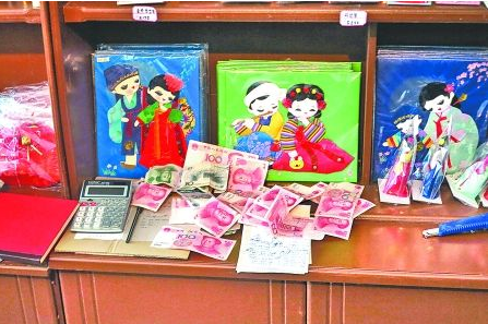 　　2012年6月21日，在朝鮮羅先特別市的一家商店里，柜臺上散落著一些人民幣。在朝鮮，人民幣比本國
