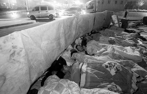 在寒冷的冬夜，為了能省點錢，方便接活，民工們仍睡在橋下。