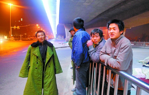 冬夜里，農民工在橋下等著干活兒。