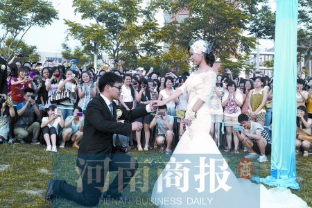 在學(xué)校操場的草坪上，兩名畢業(yè)生舉行婚禮，有同學(xué)感動地抹起眼淚