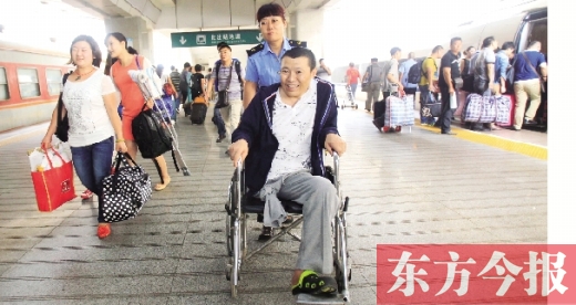 李剛手術后歸來，在車站工作人員幫助下走出鄭州火車站站臺  東方今報首席記者 張曉冬 攝