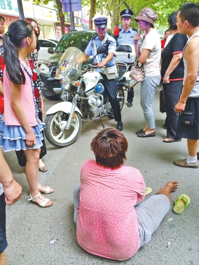 在鄭州優(yōu)勝南路東三街交叉口向東100米處，一名短發(fā)中年女子平躺在路南快車道上，身旁還有一只掉落的拖鞋