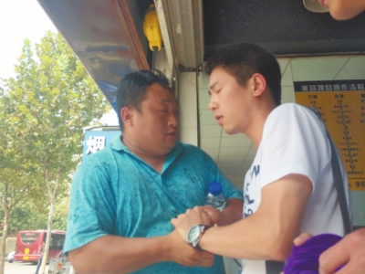 記者正查看照片，突遭藍(lán)衣男強(qiáng)搶手機(jī)。