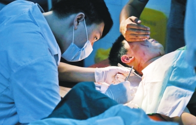 孩子身上有7道傷痕，其中兩道需要縫合，其他的均為擦傷，醫(yī)生正對(duì)他施治。