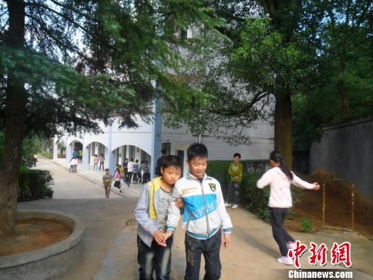 4年來(lái)，13歲的余興泉（左一）每天都攙扶著腿腳不便的同學(xué)左臣進(jìn)出教室、食堂和廁所。 李俊杰 攝