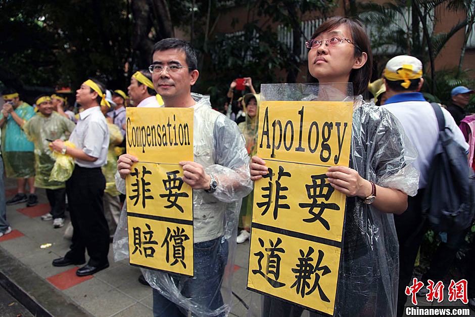 　圖為當天下午，當臺灣數(shù)百漁民在馬尼拉經(jīng)濟文化辦事處前抗議時，有兩名年輕人手持標語，在路邊聲援。中新