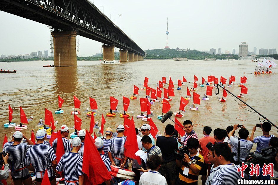 圖為江面上的橫渡方隊(duì)里的選手們劈波斬浪。中新社發(fā) 張暢 攝