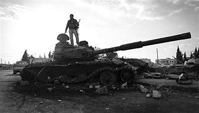 9月8日，敘利亞Zabadani，一名敘利亞反對派武裝人員站在廢棄的政府軍坦克上。